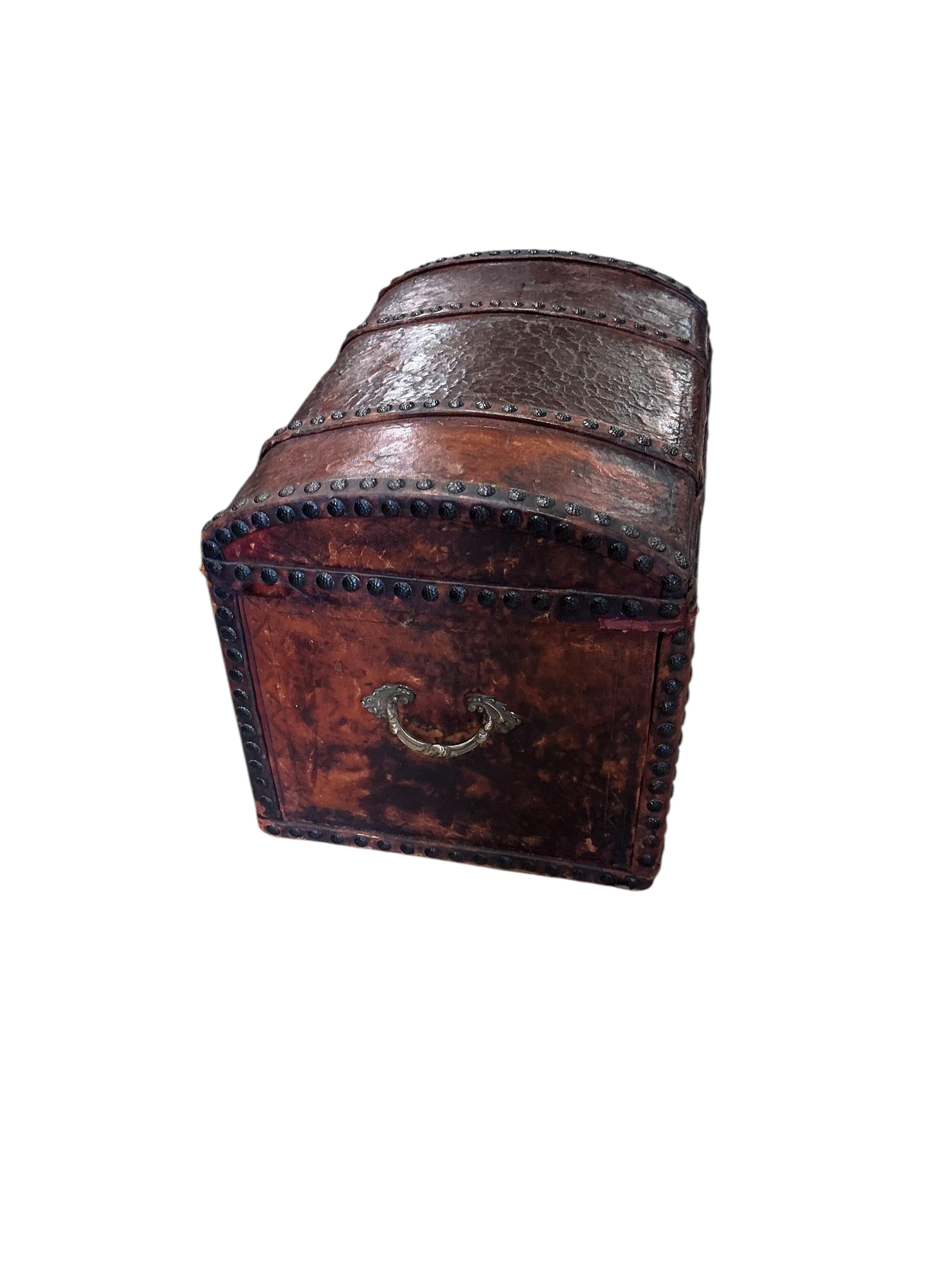 A small 18th century style studded domed top leather covered trunk with internal drawers, width 50cm, depth 35cm, height 37cm